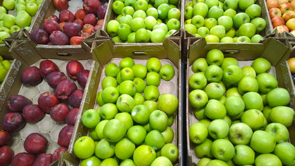 Fresh fruits, green and red apples on supermarket shelves. Retail industry. Farmers market. Discount. Rising food prices. Rich harvest. Grocery store. Healthy products. Local suppliers. Inflation.