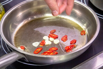 stir-fry with red pepper, typical spanish cooking, stir-fry for a paella or fideua, garlic frying in a pan with oil