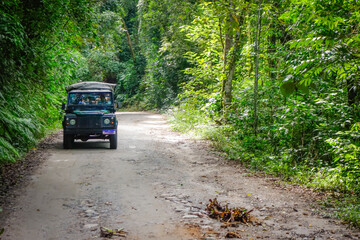 4x4 offroad jeep on dirt trail through the tropical rainforest © Caio
