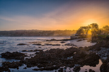 Sunrise morning rays over rocky beach in Carmel, California
