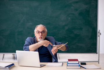 Old male teacher in the classroom