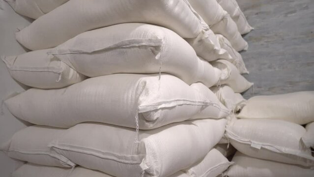 In warehouse, rice, sugar, cereals and flour are prepared in bags for shipment to consumer. Production, technological equipment, conveyor, technological plant Industrial plants. Bakery