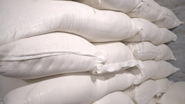 In warehouse, rice, sugar, cereals and flour are prepared in bags for shipment to consumer. Production, technological equipment, conveyor, technological plant Industrial plants. Bakery