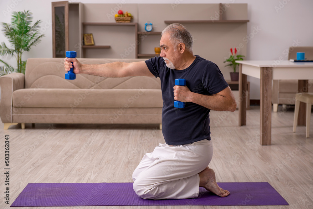 Wall mural old man doing sport exercises at home