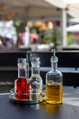 Bottles of olive oil, balsamic vinegar and wine stand on black table