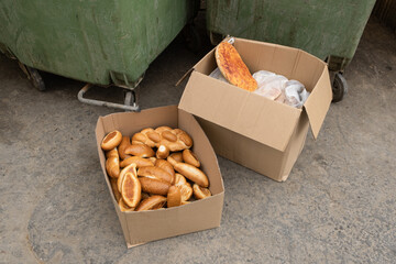 Carton box with bread in it, near a waste container in Israel. left for homeless and hungry people...