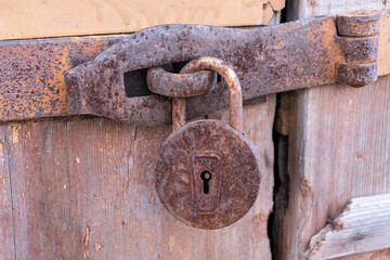 Old wooden door with old retro metallic  hinged lock