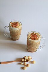 Coffee with macadamia nuts and caramel for dessert break on white background.