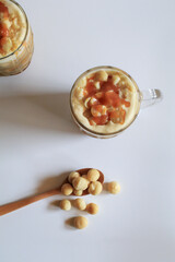 Coffee with macadamia nuts and caramel for dessert break on white background.