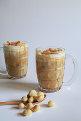 Coffee with macadamia nuts and caramel for dessert break on white background.