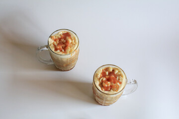 Coffee with macadamia nuts and caramel for dessert break on white background.