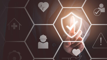 Work safety concept. Businessman touching check mark in shield icon. Safety first sign on virtual...