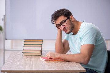 Young male student preparing for exams in the classroom