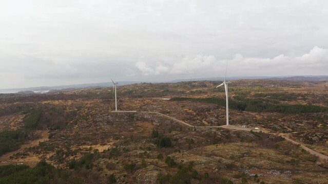 Lindesnes windpark in Southern Norway - Two 98 meter tall rotating windturbines producing electricity for Asko Fornybar Norway - Aerial overview at cloudy day