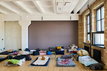 Spacious room with rows of beds or temporary sleeping places prepared for migrants or refugees for...