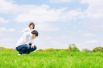 Naklejka na ściany i meble 草原で遊ぶ女の子とパパ　子育てイメージ　ファミリー