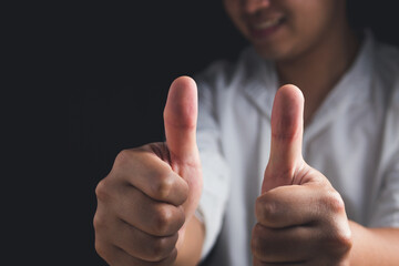 Person that white shirt shows thumbs up sign. Salary man or business man smiles. Like or good concept. Close up shot with copy space.