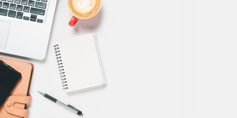 Office desk with laptop computer, pen, smart phone, notebook, Cup of coffee on white background, Top view with copy space, Mock up..