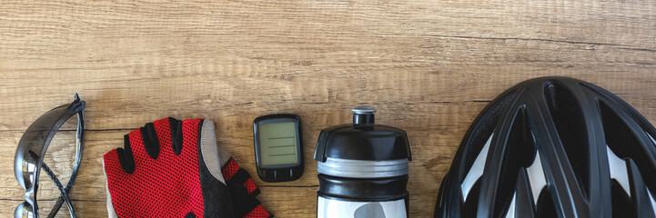 Banner with cycling accessories in a row of black helmet, water bottle, goggles, bike computer and...