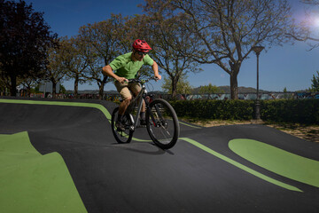 cyclist on a pump track circuit passing through a boost zone - obrazy, fototapety, plakaty