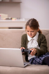 Young little girl playing joystick games at home