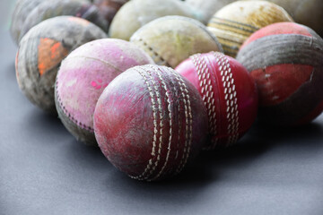 Old and used cricket balls on dark background used for cricket practice, soft and selective focus.