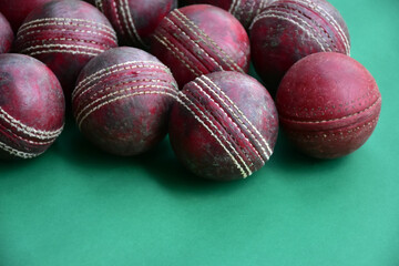 Old and used cricket balls on green background used for cricket practice, soft and selective focus.