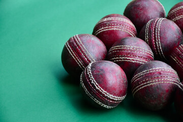 Old and used cricket balls on green background used for cricket practice, soft and selective focus.