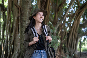 Asian young beautiful female backpacker traveling alone in forest wild. 