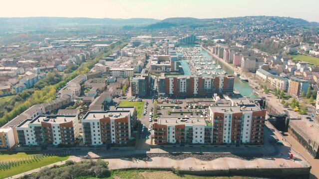 Aerial view of waterside apartments and rows of boats and docks in city marina