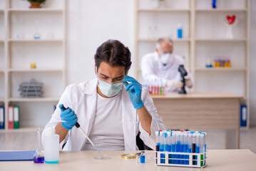 Two male chemist working at the lab