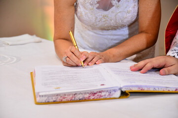 bride signing wedding document, bride signing the ledger, bride signing the book with golden pen, marriage certificate, bride signing book, woman signing document, document signing, contract signing