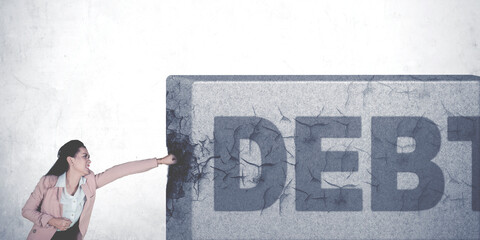 Businesswoman punching debt word on the stone