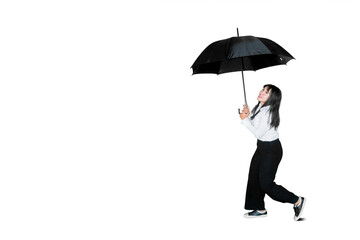 Businesswoman walking with umbrella on studio