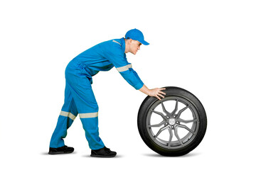 Caucasian male mechanic push a car wheel on studio