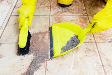 Hands sweeping dust with broom and dustpan - obrazy, fototapety, plakaty