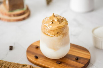 Dalgona coffee with fluffy cream served on wood tray.Homemade trendy beverage menu on social media