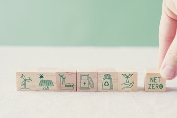 Hand holding net zero concept wooden blocks, carbon neutral, greenhouse gas emissions reduction...