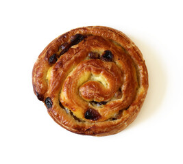 Ruddy spiral bun with raisins isolated on white background.