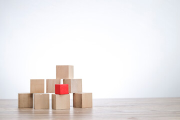 A red wooden block on top of the stacked wooden blocks isolated on white background