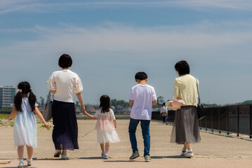 夏の海岸の堤防で散歩している親子たちの姿