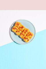 Hot sushi roll with cream cheese top and crispy onion. Baked sushi with salmon, cream cheese topped. Hot maki sushi  on coloured background in minimal style.