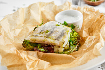 White fish fillet with broccoli in rustic style. Healthy eating: cooked fish fillet with vegetables garnish. Diet food with whitefish and broccoli. Steam vegetables with roasted zander fillet.