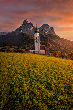 Seis am Schlern, Italy - Beautiful sunset and idyllic mountain scenery in the Italian Dolomites with St. Valentin Church and famous Mount Sciliar with colorful clouds and warm sunlight at South Tyrol