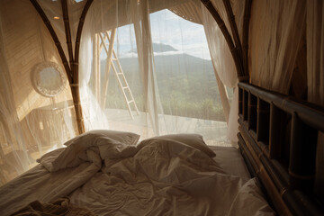 Bed with a beautiful view of the mountains from a bamboo house. Bamboo house with mountain or...