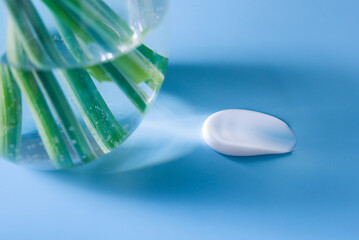 cosmetic smear of cream on a blue background with a beam of light	
