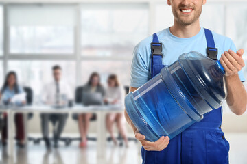 Delivery man with big bottle of water in office