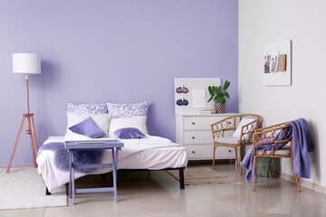 Interior of stylish bedroom with lilac wall
