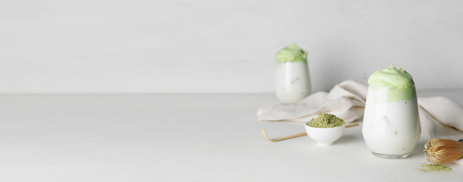 Glass of tasty dalgona matcha latte on light background with space for text