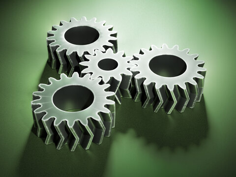 gear mechanism - scratched metallic double helical gears on a surface painted with green metallic paint 